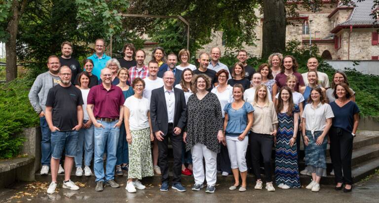 Das Kollegium des Gymnasiums am Rosenberg ist auf dem Schulhof zum Gruppenfoto versammelt.