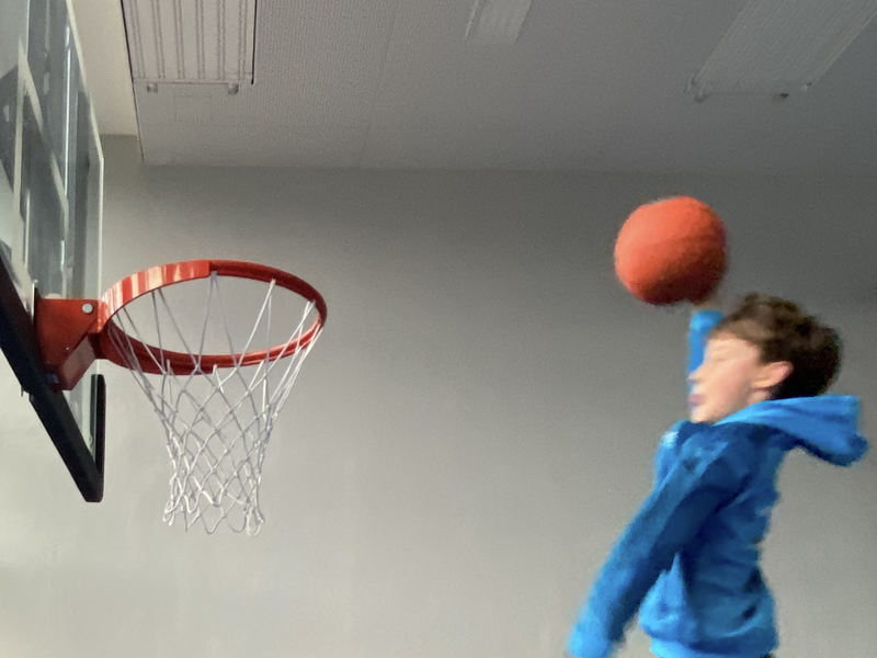 Schüler wirft einen Ball in den Basketballkorb