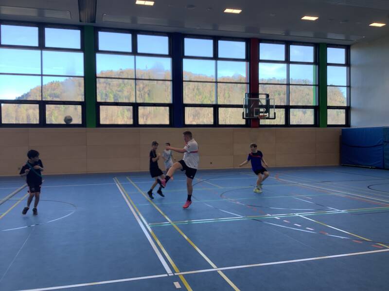 Schüler spielen Fußball in der Sporthalle.