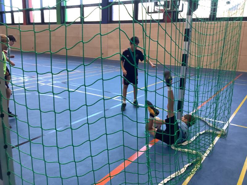 Schüler spielen Fußball in der Sporthalle.